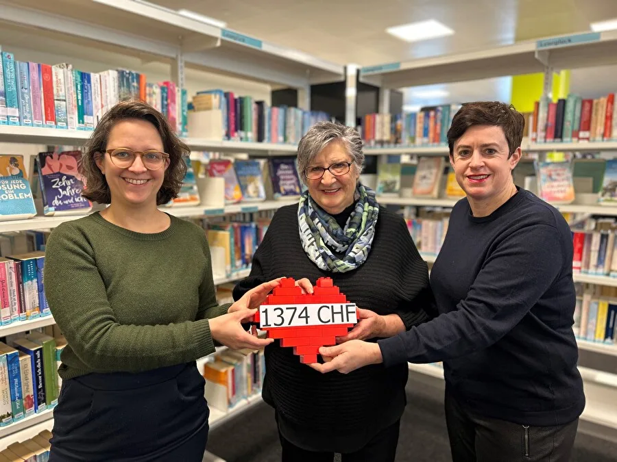 Maximiliane Kroiss von der Stadtbibliothek Uster (links) übergibt zusammen mit Silvia Kölliker von der Fachstelle Alter (rechts) den Betrag an Mägi Müller vom Verein Seniorennetz (Mitte). Man sieht Maximiliane Kroiss von der Stadtbibliothek zusammen mit Silvia Kölliker von der Fachstelle Alter, die den Betrag an Mägi Müller vom Verein Seniorennetz übergeben.